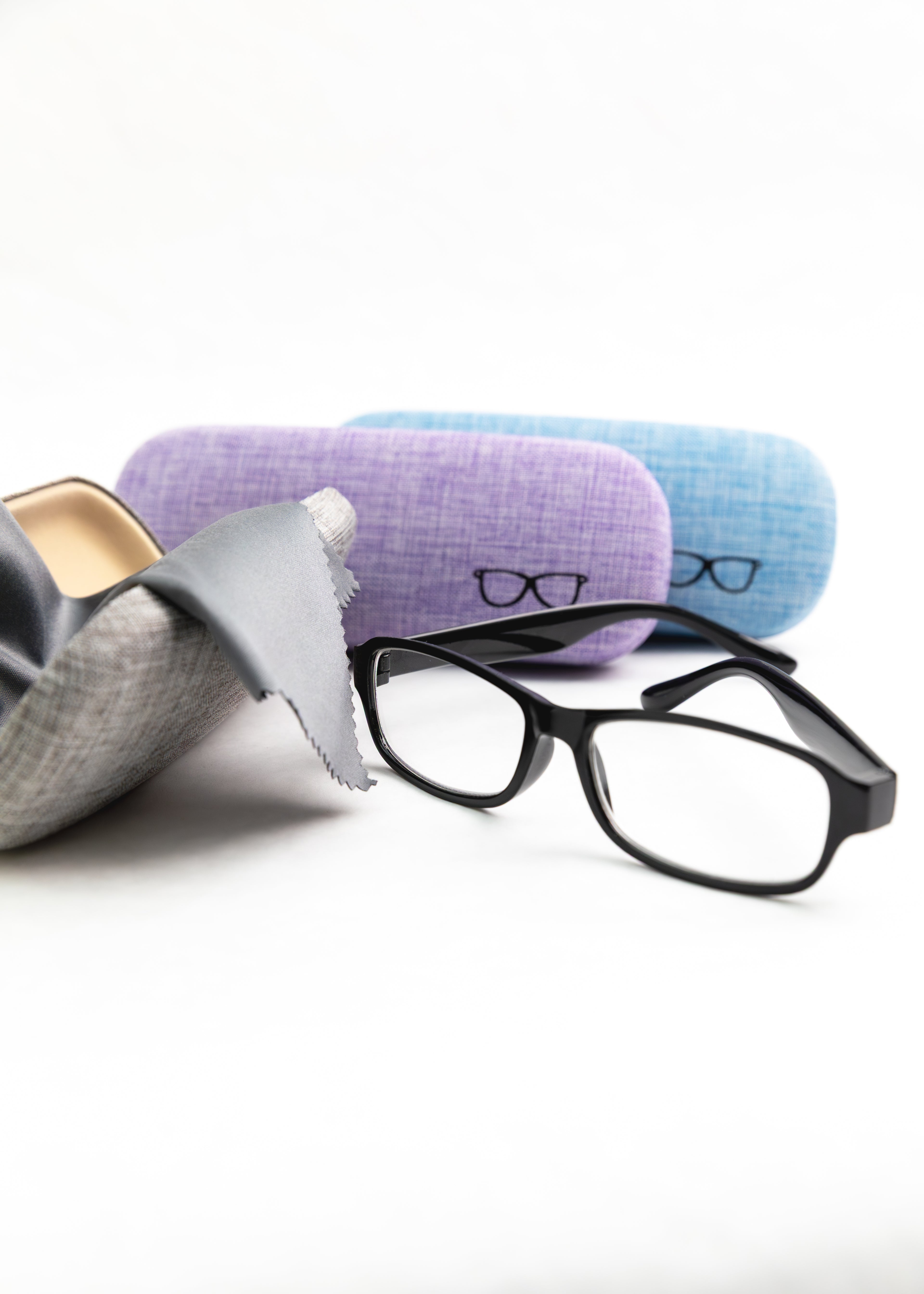 Black eyeglasses with gray and purple cases on a white background