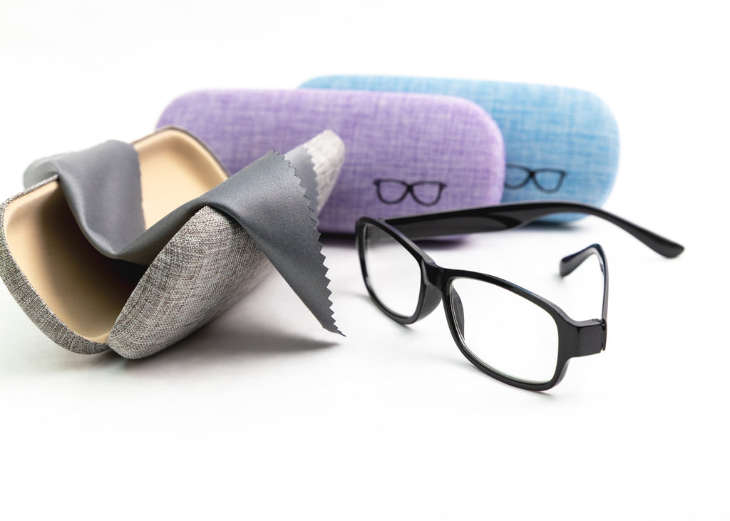Eyeglasses with three different colored cases on a white background